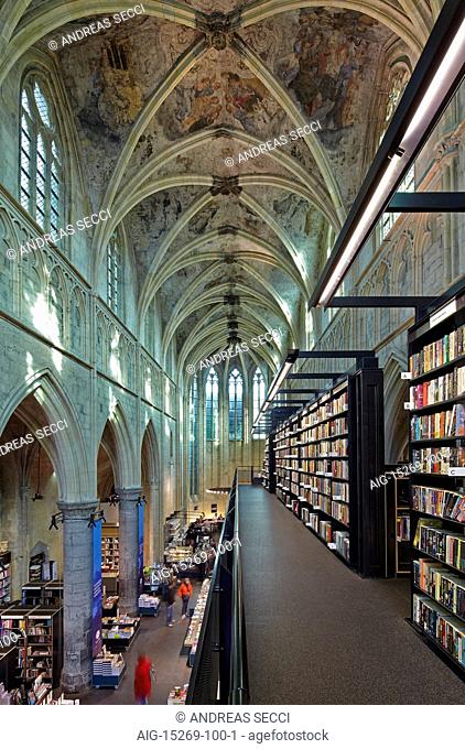 Selexyz Dominicanen Bookshop, built within a former 13th century Gothic church building. Shelving and displays and views of the arched roof