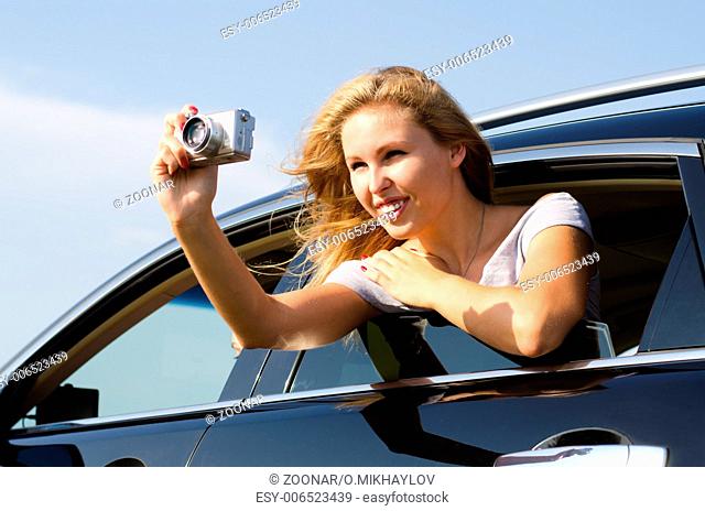 Tourist taking photographs from a car window