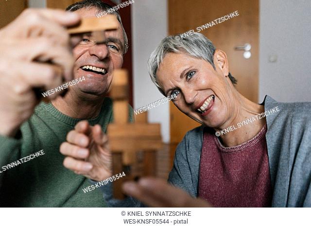 Happy senior couple playing dexterity game at home