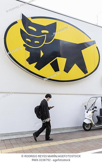 February 21, 2019, Tokyo, Japan - A man walks past a logo of Yamato Holdings in Ginza district. Yamato Transport Co., Ltd