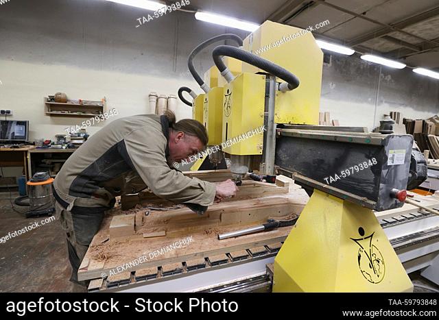 RUSSIA, ST PETERSBURG - JUNE 13, 2023: A woodworker in the mechanical working shop at the Resonance Harps musical instrument factory