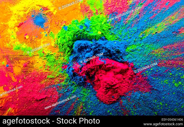 Abstract colorful Happy Holi background. Color vibrant powder on wood. Dust colored splash texture. Flat lay holi paint decoration