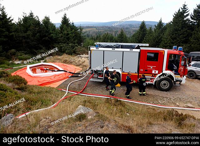 06 September 2022, Saxony-Anhalt, Schierke: Firefighters stand at the Goetheweg station and coordinate the water supply in the area of operation at the Brocken