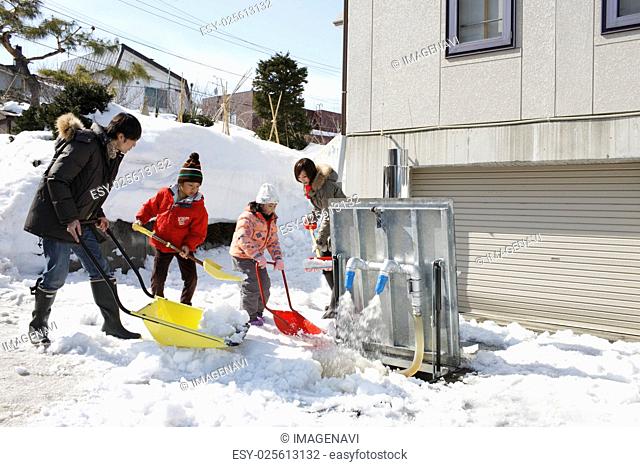 Family removing snow