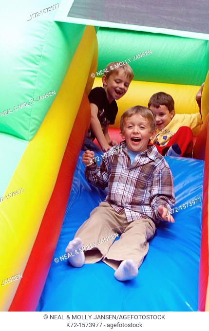 Little boys excited on slide on an inflatable ride