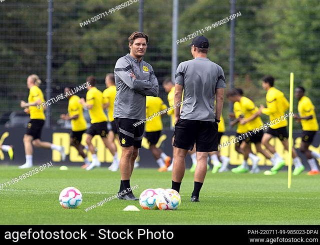 11 July 2022, North Rhine-Westphalia, Dortmund: Training Borussia Dortmund on the club's own training ground: Dortmund's coach Edin Terzic (l) follows the...
