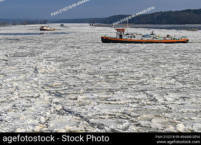18 February 2021, Brandenburg, Schwedt: Icebreakers navigate on the German-Polish border river Oder. Drift ice is increasing the risk of flooding in some...