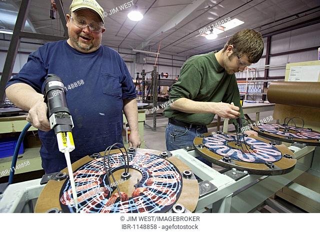 Workers assemble the generators of Windspire wind turbines; the Windspire is a small, vertical axis wind turbine designed for residential or small business use
