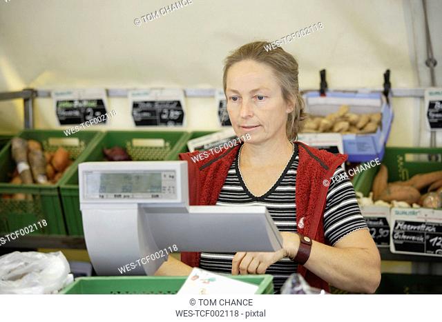 Germany, Upper Bavaria, Wolfratshausen, Mature woman buying vegetables from market