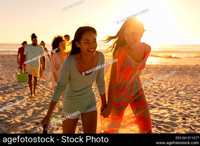 Mixed race friends group walking on beach