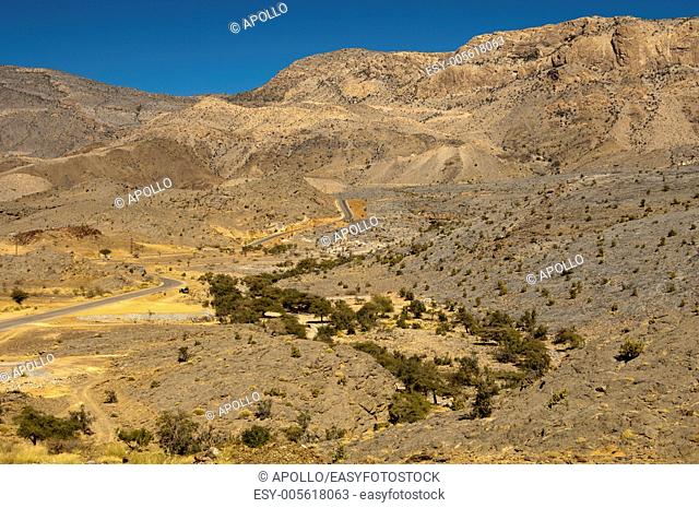 Tarmac road near Al Hamra runs through a wild mountain landscape leading to the viewpoint at Jebel Shams, Sultanate of Oman