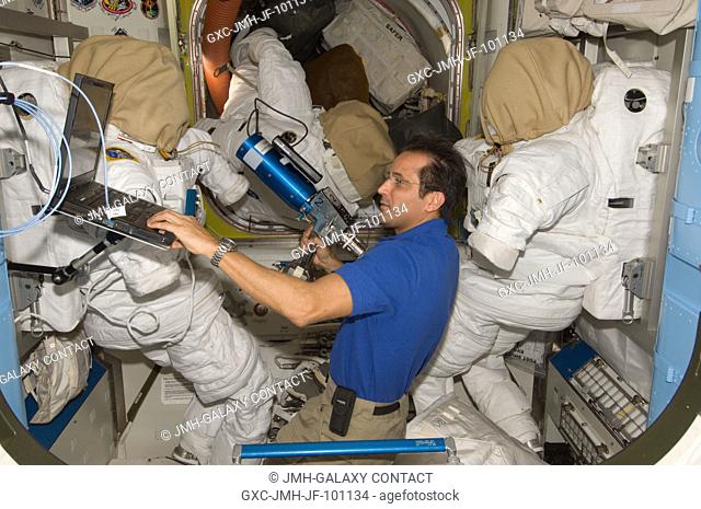 NASA astronaut Joe Acaba, Expedition 31 flight engineer, uses a computer while working with extravehicular activity (EVA) tools in the Quest airlock of the...
