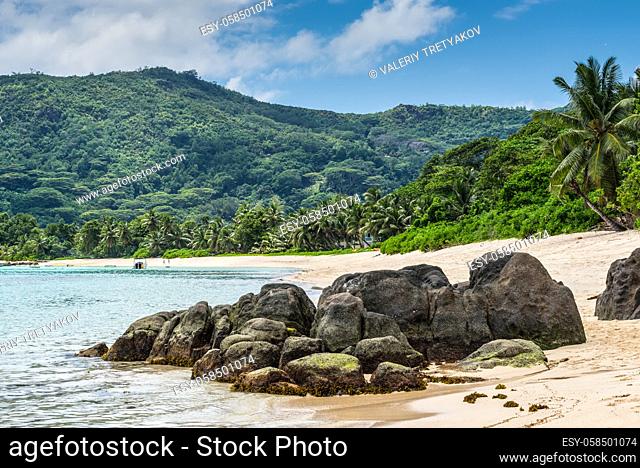 Tropical beach Anse Royale with granite boulders in the foreground at Mahe island, Seychelles - vacation background