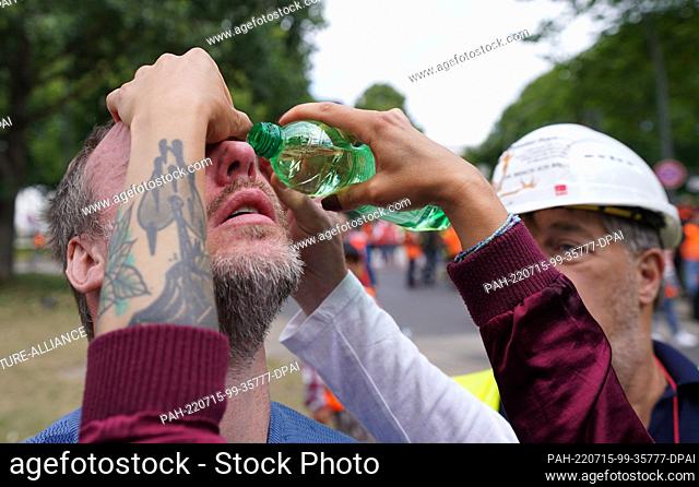 15 July 2022, Hamburg: Helpers flush out the eyes of a participant in a demonstration by port workers in the city center after police intervention