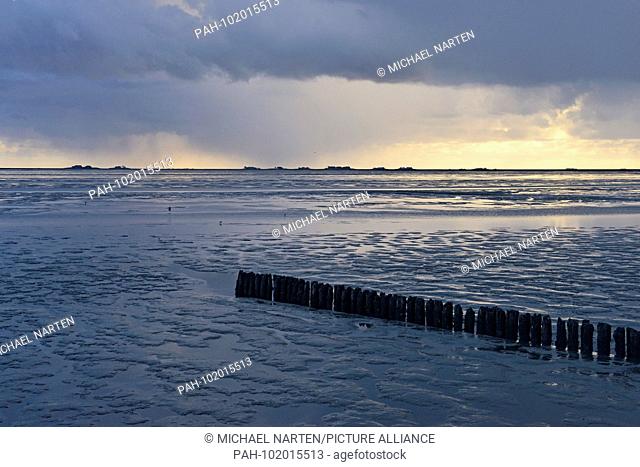 Heavy dark rain clouds above the North Frisian Wadden Sea with the dwelling mounds from Hallig Langeneß on the horizon, 23 April 2016 | usage worldwide