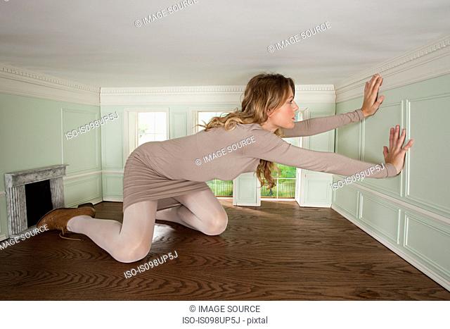 Giant young woman trapped in small room