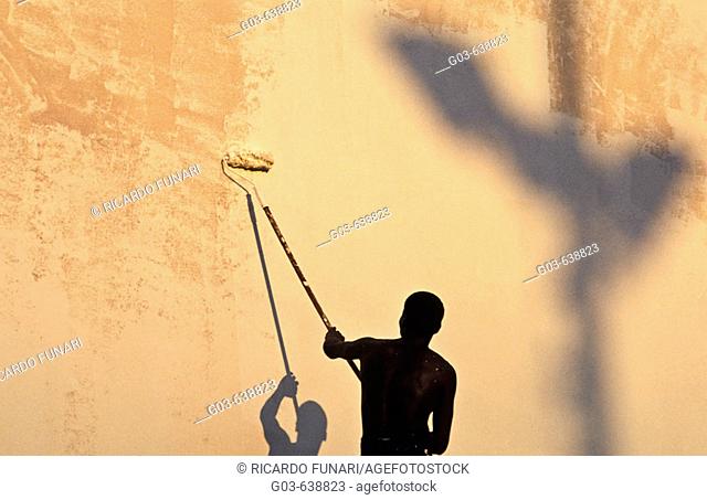 Black worker. Wall painter. Informal economy, Rio de Janeiro, Brazil
