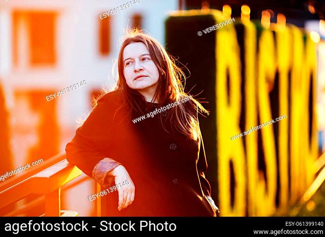 Businesswoman in the street at sunset. Portrait of elegant woman in an urban setting. Selective focus