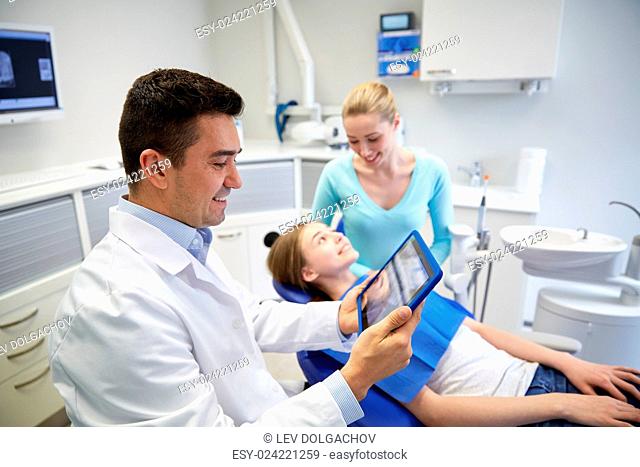 people, medicine, stomatology, technology and health care concept - happy male dentist looking at teeth x-ray on tablet pc computer and patient girl with her...