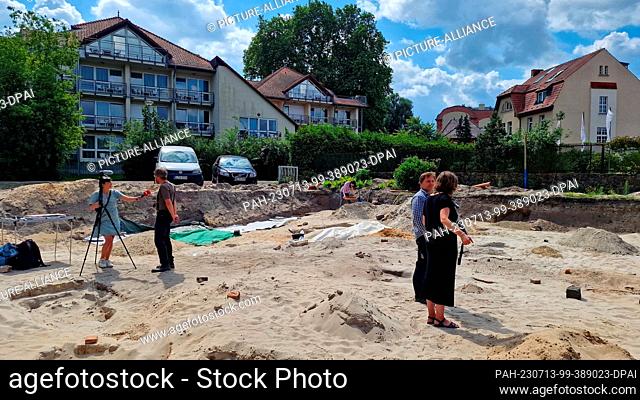 13 July 2023, Brandenburg, Brandenburg an der Havel: Journalists inform themselves about the grave site in a residential area