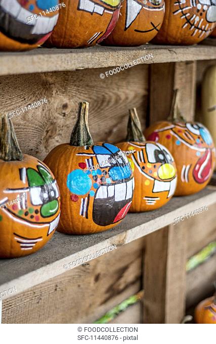 Painted Halloween pumpkins on a wooden shelf