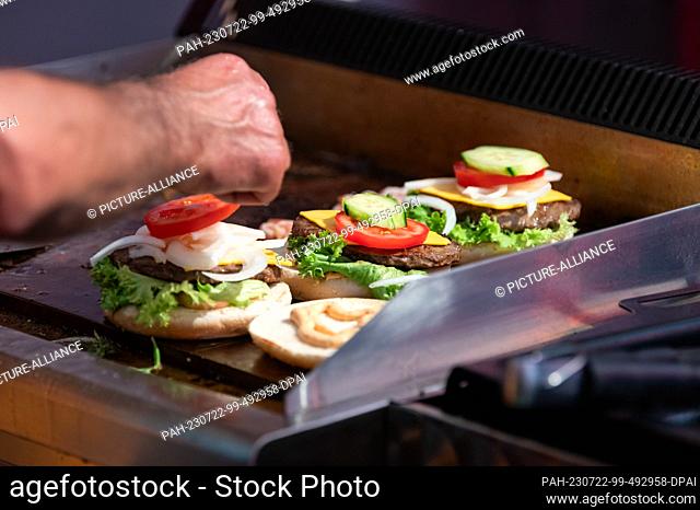 SYMBOL - 21 July 2023, Baden-Württemberg, Rottweil: Burgers are prepared at a food stand at an event in Rottweil. Photo: Silas Stein/dpa