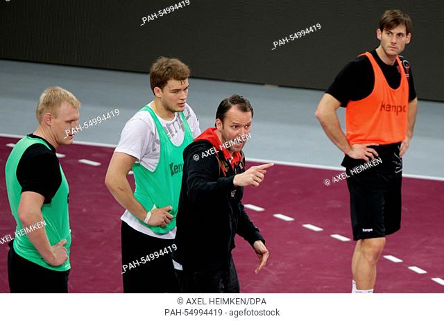 Germany's head coach Dagur Sigurdsson (C) talks to Germany's Patrick Wiencek (l-r), Paul Drux and Uwe Gensheimer during the training of Team Germany during the...