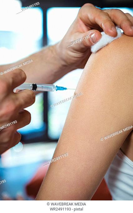 Female patient receiving injection from physiotherapist