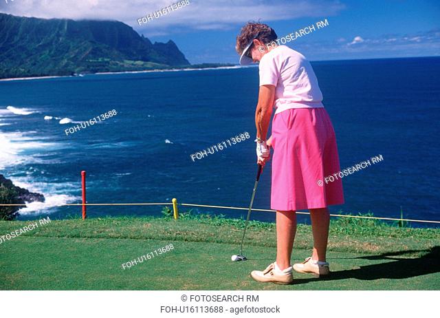 Female golfer putting in Kauai, Hawaii