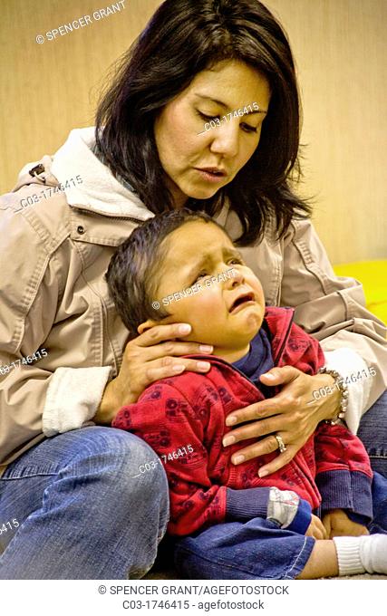 A Hispanic teacher comforts a disoriented frightened vision-impaired boy in a sensory motor group at the Blind Children's Learning Center in Santa Ana, CA