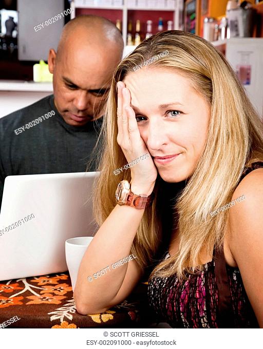 Bored woman with man on laptop computer