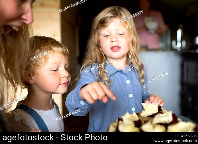 Hermanas mirando pasteles dulces en la placa