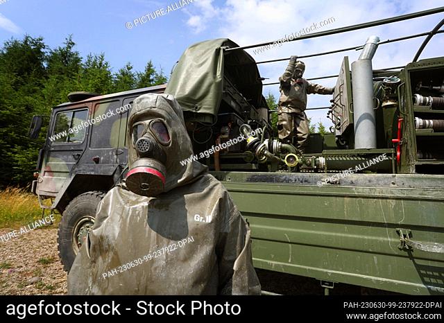 29 June 2023, Bavaria, Sonthofen: Ukrainian soldiers stand by a truck with HEP70 decontamination equipment during NBC defense training at a Bundeswehr site...