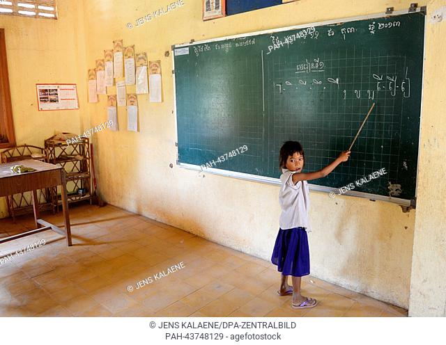 A girl points to Khmer script on the blackboard in a nicely decorated classroom of the Kdei Chas Primary School in Phnom Penh, Cambodia, 11 October 2013