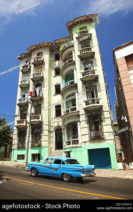 Old American car used as taxi in front of the colonial buildings with balconies at Vedado district, Havana, La Habana, Cuba, West Indies, Central America