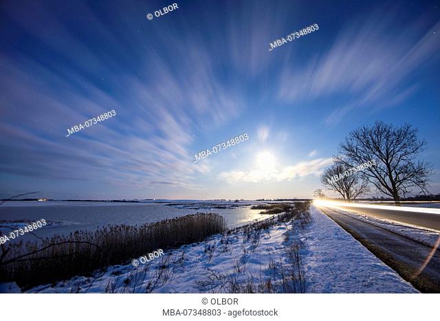 Germany, Mecklenburg-Vorpommern, winter landscape near Poel at night with full moon and road