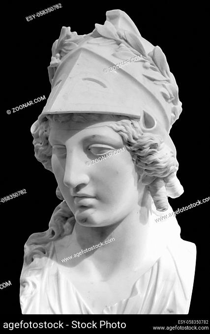 Greek ancient statue of goddess Athena. Woman marble head in helmet sculpture isolated on black