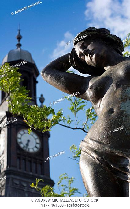 One of the eight Alfred Drury sculpted statues with Old Post office clock, City Square, Leeds, Yorkshire, England