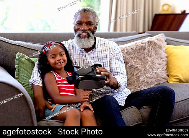 Senior African American man and his granddaughter using vr headset