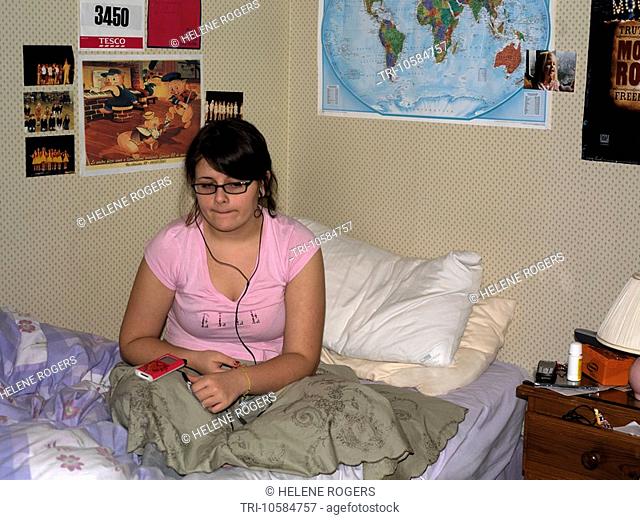 Teenager Listening to Music on iPod in Bedroom