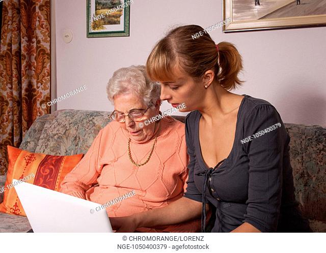An old woman is a laptop explained by her granddaughter
