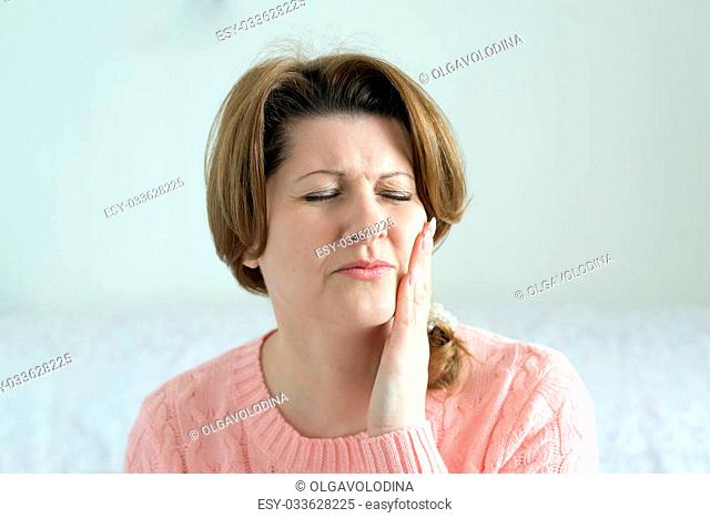 Young woman in pain is having a toothache