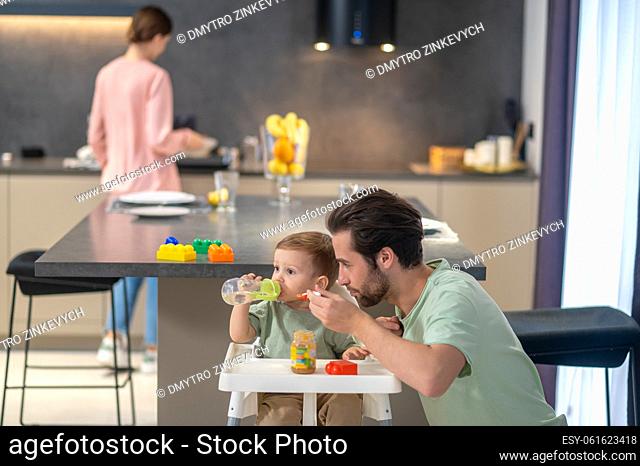 Breakfast time. Dad, mom and a small son in the kitchen at home