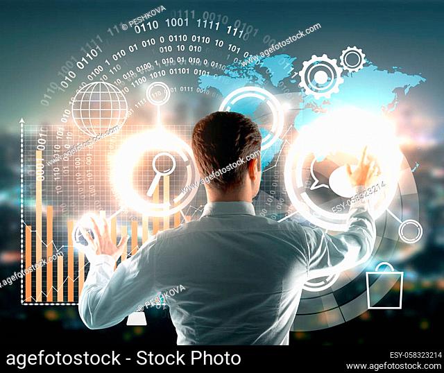 Back view of young businessman managing abstract business hologram on blurry city background. Fund management, networking concept. Double exposure
