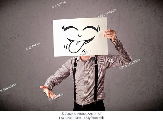 Businessman holding a paper with funny smiley face in front of his head