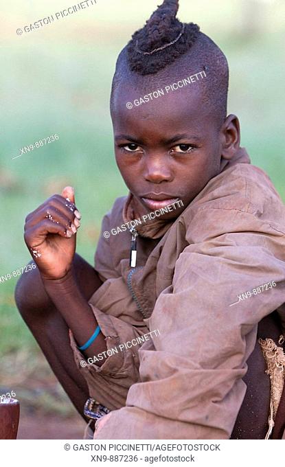 Himba boy, with his dirty hand with food.  Kaokoland, Namibia