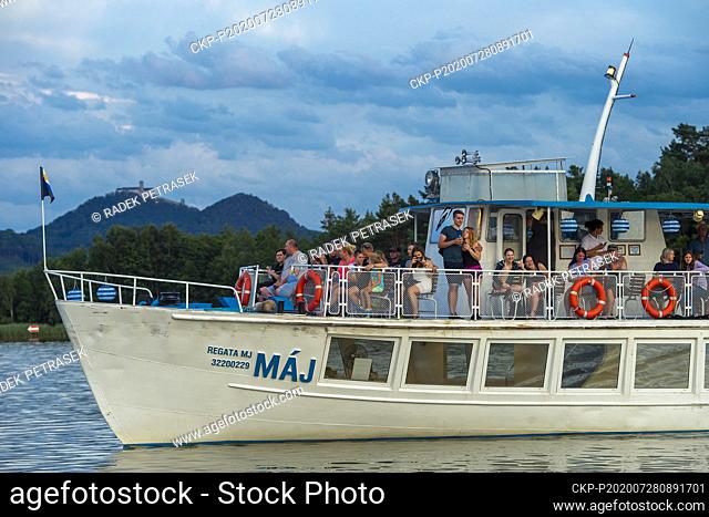 Evening cruise of the boat May (Maj) on Lake Macha (Machovo jezero) is seen on July 28, 2020, in Doksy, Czech Republic. On the background is seen Bezdez castle