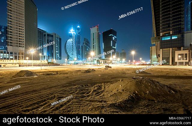 Sand surface and construction sites of high-rise buildings in Business Bay at night, Downtown Dubai, United Arab Emirates
