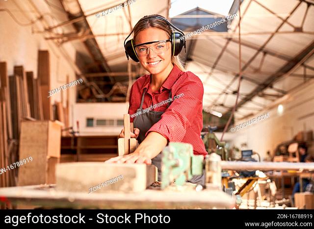 Junge Frau in der Schreiner Lehre arbeitet mit dem Handhobel in der Werkstatt