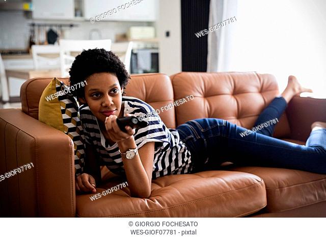 Young woman watching Tv at home